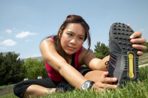 Woman stretching in a field before running.
